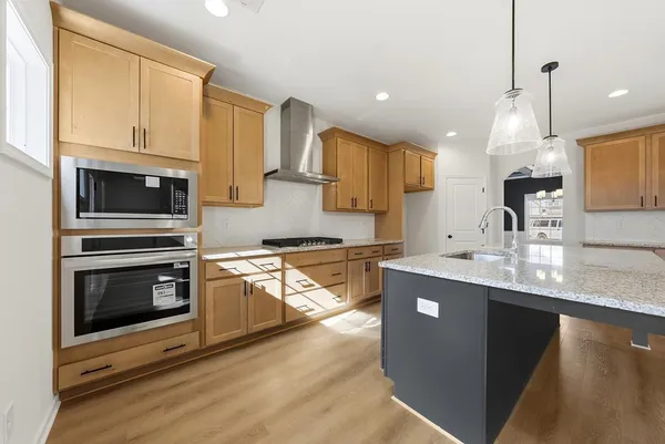 a kitchen with stainless steel appliances kitchen island granite countertop a stove a sink and a microwave