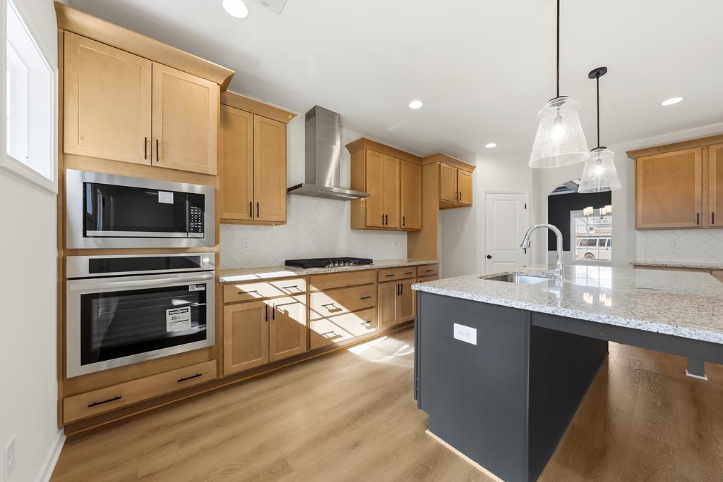 1304 McAlpine Ridge Auburn, AL 36830 - Photo 7 of 34 a kitchen with stainless steel appliances kitchen island granite countertop a stove a sink and a microwave