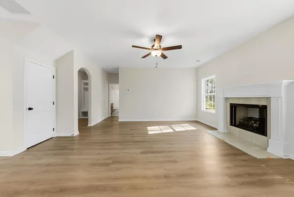 a view of empty room with wooden floor and fireplace