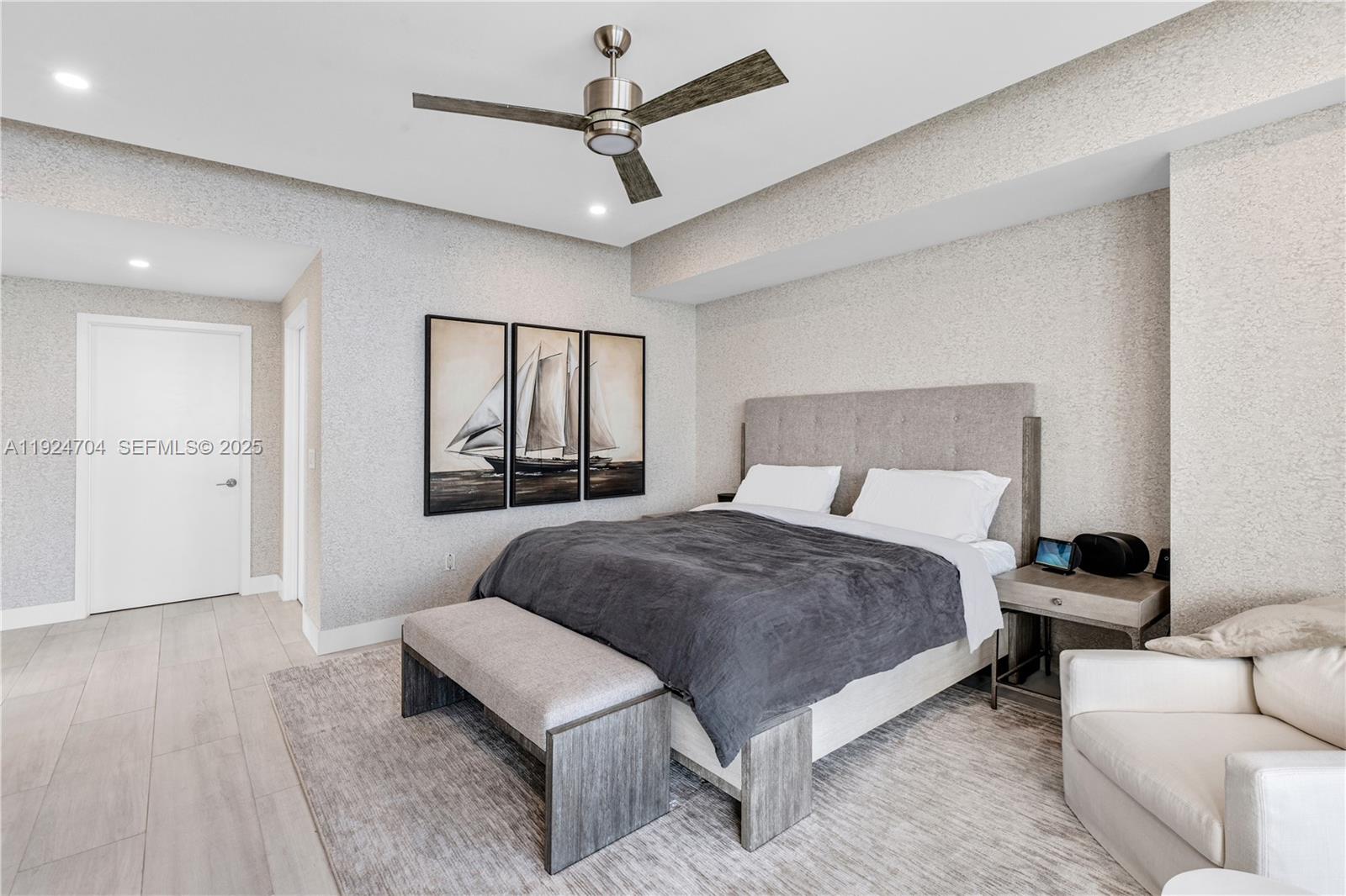 788 Northeast 23rd Street, Unit 2201 Miami, FL 33137 - Photo 8 of 29 a spacious bedroom with a bed a couch and a chandelier