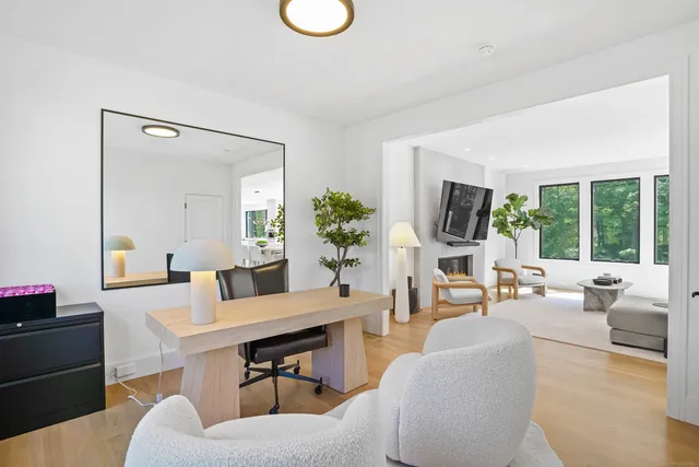 a living room with furniture fireplace and a large window