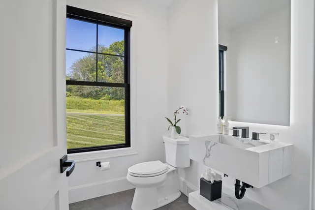 a bathroom with a sink toilet and mirror