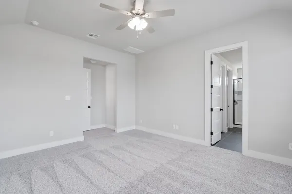 an empty room with closet and a chandelier fan