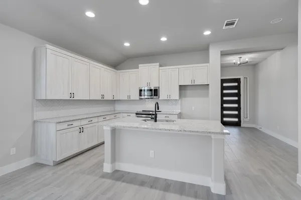 a kitchen with a sink cabinets and wooden floor