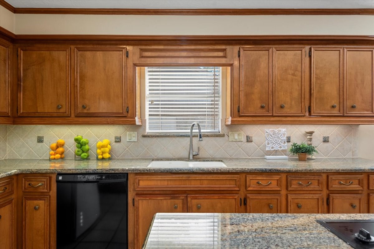 16707 Rugby Court Spring, TX 77379 - Photo 12 of 48 The neutral tile backsplash and window above the kitchen makes this room feel bright and airy.