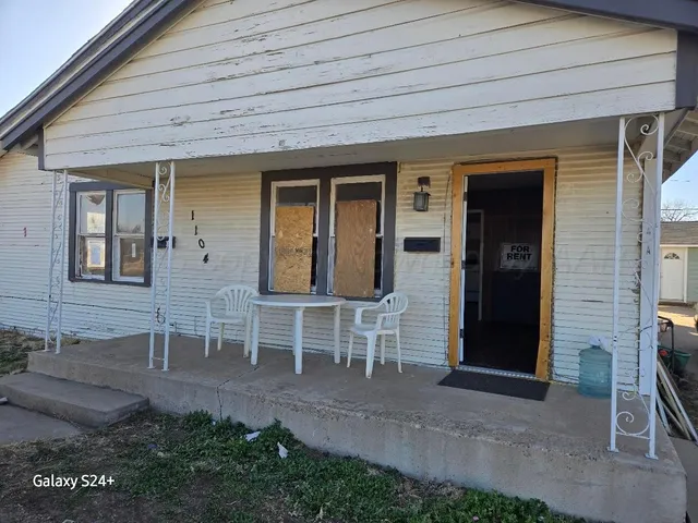 a view of front door of house with outdoor seating