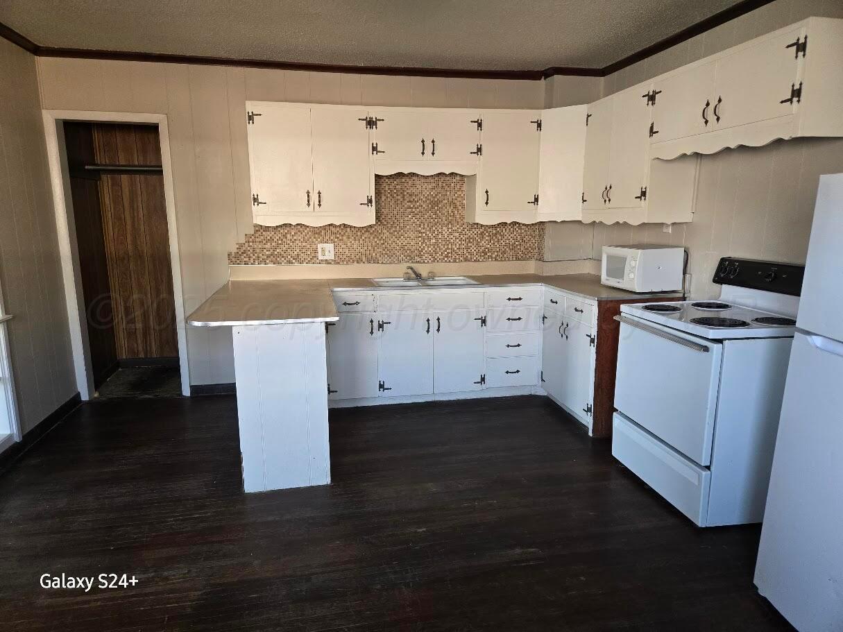 1104 South Western Street Amarillo, TX 79106 - Photo 11 of 24 a kitchen with cabinets stove and refrigerator