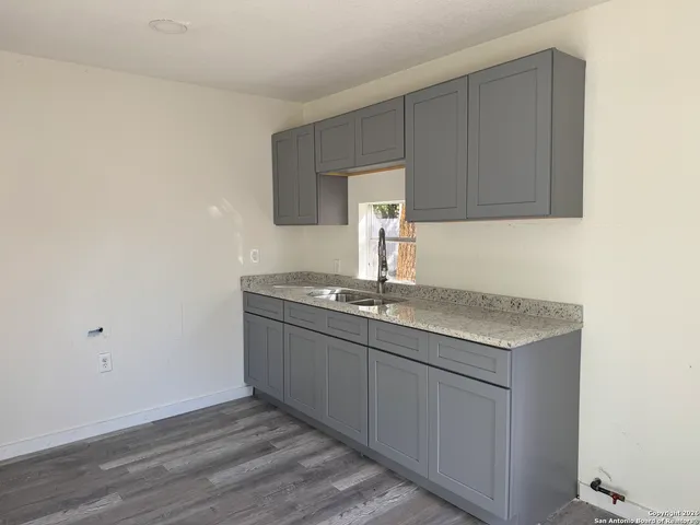 a kitchen with granite countertop a sink and cabinets