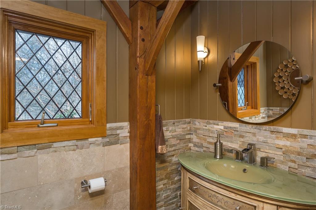6111 Meadow Bluff Lane Oak Ridge, NC 27310 - Photo 15 of 30 Every detail was carefully planned in the 2009-2010 redo! Stacked stone wainscoting, diamond mullions, wood tongue & groove walls, specialty mirror and lighting fixtures. This is the half bath.