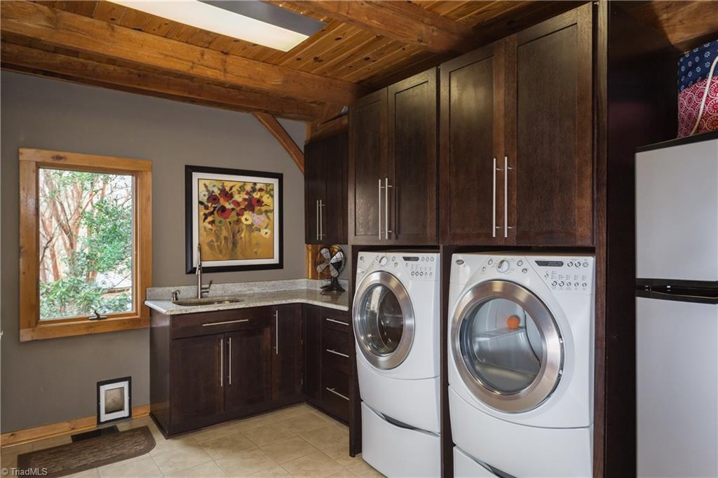 6111 Meadow Bluff Lane Oak Ridge, NC 27310 - Photo 17 of 30 Even the laundry is extraordinary. Oversized, porcelain tile floor, granite countertops with wash sink, utility closet and spare room for dog crates, extra freezer or refrigerator. All interior doors are wood.