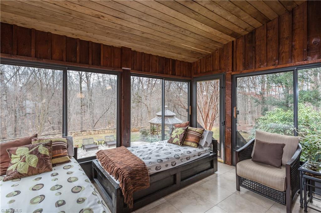 6111 Meadow Bluff Lane Oak Ridge, NC 27310 - Photo 18 of 30 My personal favorite spot is the sleeping porch! Tile floor, mounted TV, this three season room can be an extension of the kitchen gathering area.