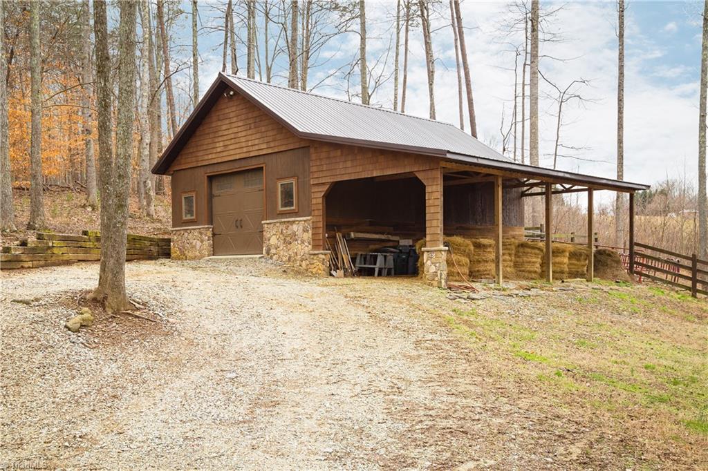 6111 Meadow Bluff Lane Oak Ridge, NC 27310 - Photo 29 of 30 The barn is new with a concrete floor but no stalls. Right now it serves as great storage. Additional clearing would have to be done for this to be a horse property. Perfect though for goats, chickens, sheep and llamas.