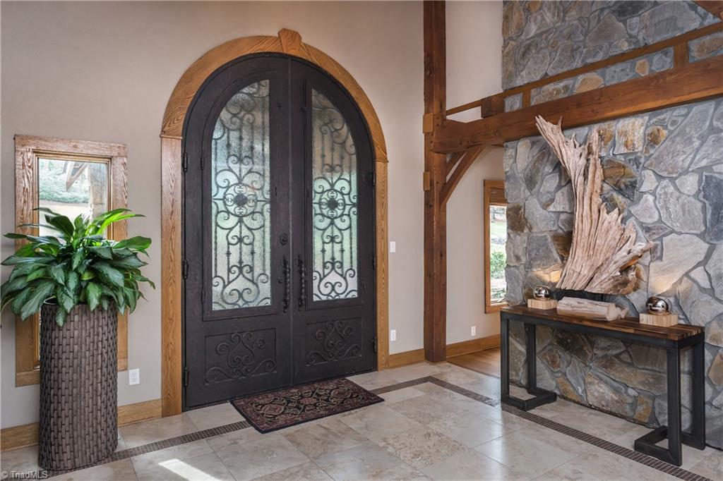 6111 Meadow Bluff Lane Oak Ridge, NC 27310 - Photo 6 of 30 You have got to feel the weight of this door. Designed by the sellers and hand crafted especially for this property it is amazing. The entry is terrazzo flanked by oak beams and a floor to ceiling stone wall.