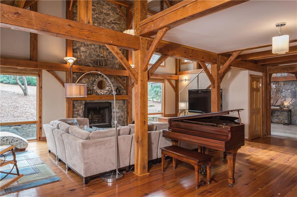 6111 Meadow Bluff Lane Oak Ridge, NC 27310 - Photo 7 of 30 The 26 ft. great room is spectacular. Two story tongue and groove wood ceiling, heart pine random width flooring, post and beam construction and a massive stone wood burning fireplace.