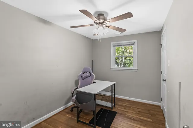 a view of a workspace with wooden floor and a window