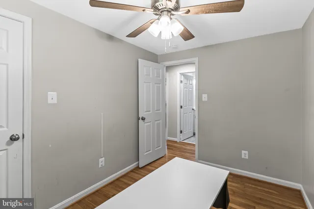 a view of a room with a chandelier fan and a ceiling fan