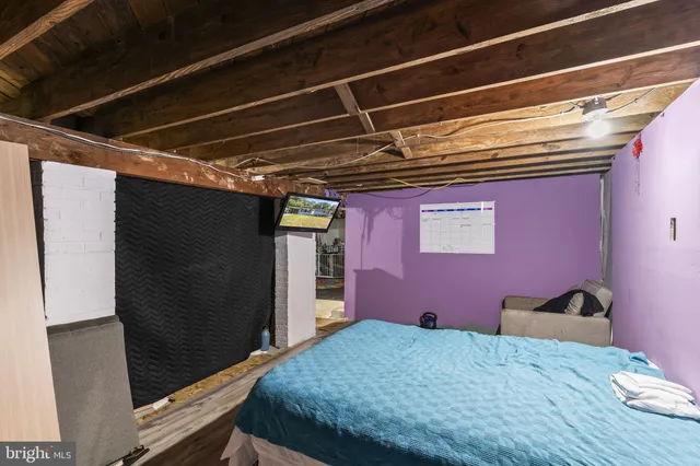 a bed sitting in a bedroom next to a window