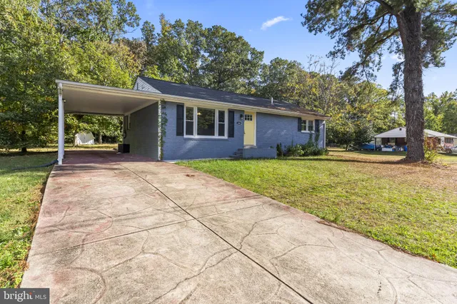 a front view of a house with a yard and trees