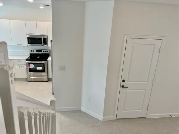 a kitchen with stainless steel appliances a stove a microwave and white cabinets