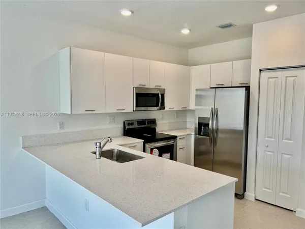 a large kitchen with a large counter top appliances and cabinets