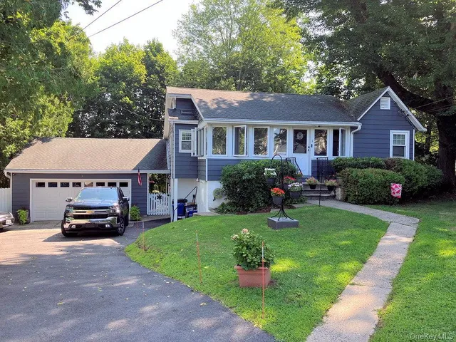 a view of house with outdoor space and car parked