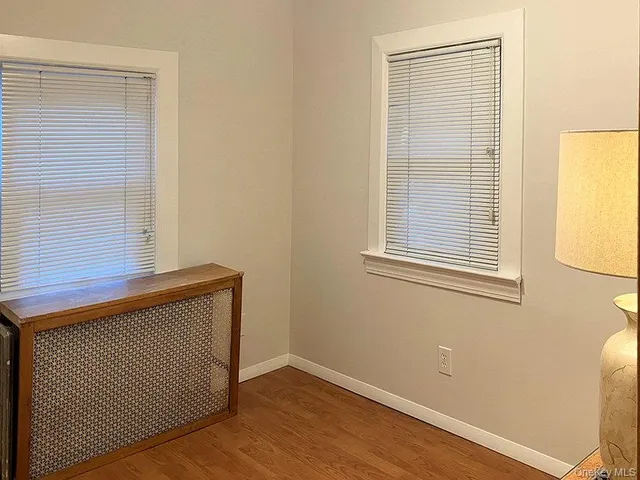 a view of a hallway with wooden floor and a window