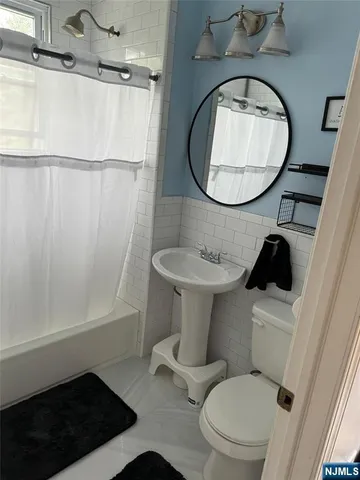 a bathroom with a toilet a sink and a mirror