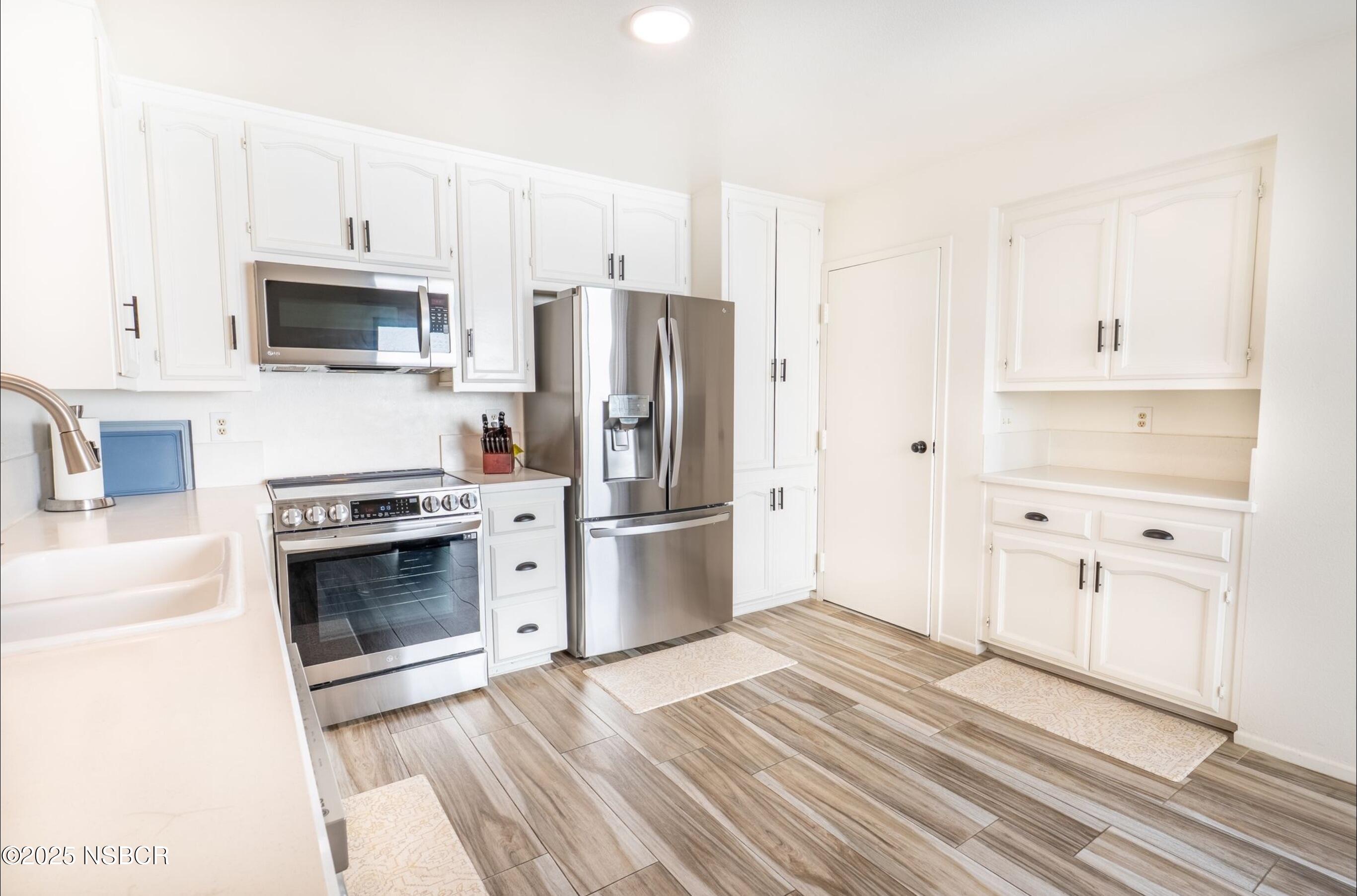 5 Stanford Circle Lompoc, CA 93436 - Photo 5 of 21 a kitchen with stainless steel appliances white cabinets and a refrigerator