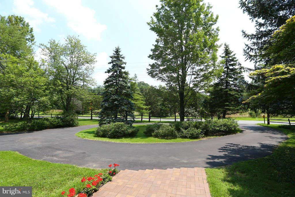 12530 Falls Road Potomac, MD 20854 - Photo 2 of 27 a view of street with a big yard and large trees