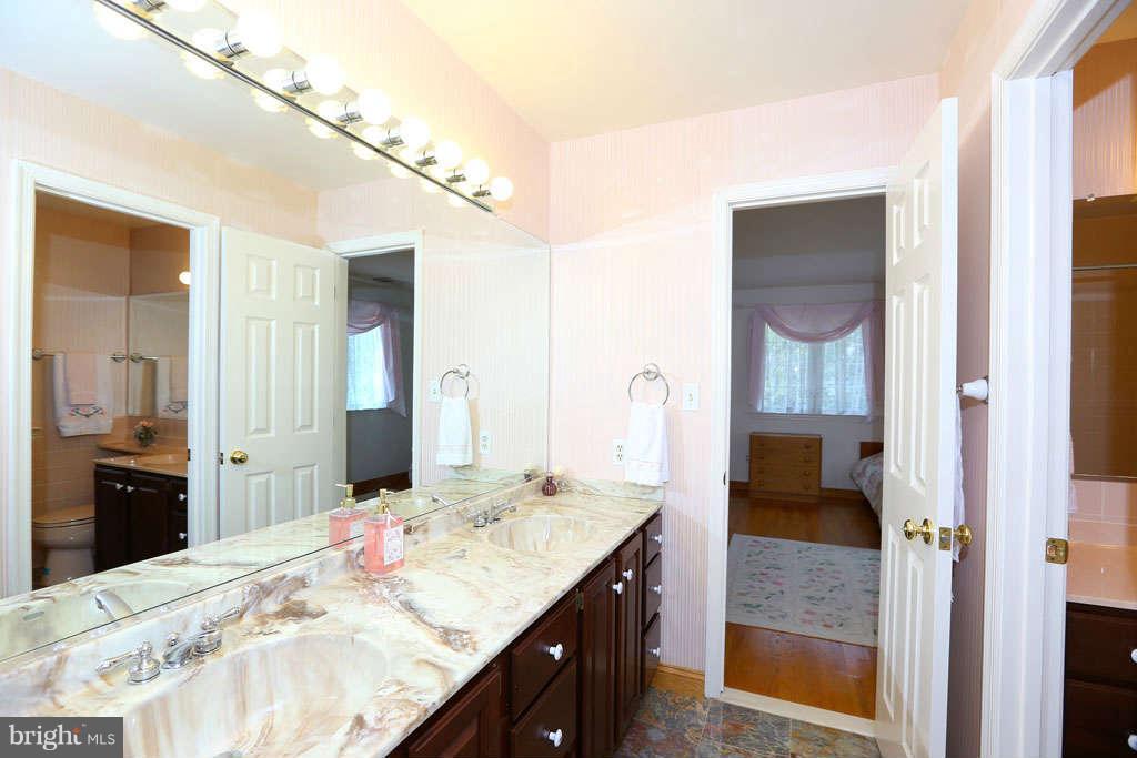 12530 Falls Road Potomac, MD 20854 - Photo 16 of 27 a en suite bathroom with a granite countertop sink and a mirror