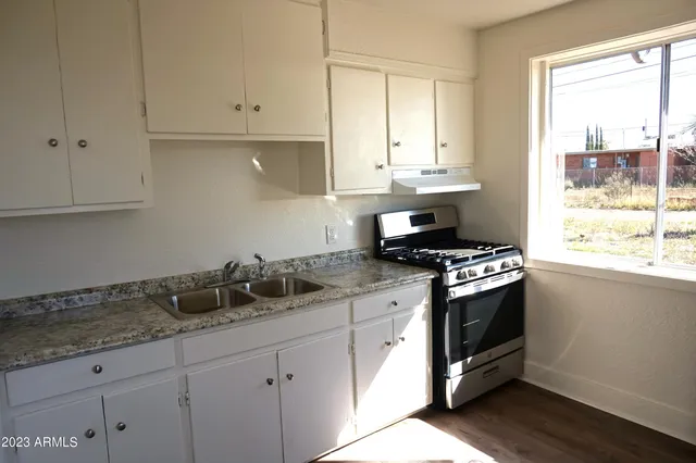 a kitchen with granite countertop white cabinets and white appliances