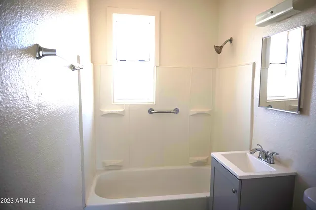 a white bath tub sitting next to a white sink and vanity