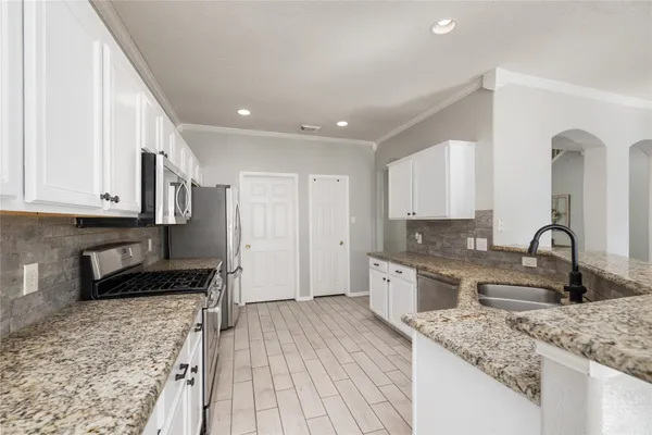 a view of a kitchen with wooden floor and a sink