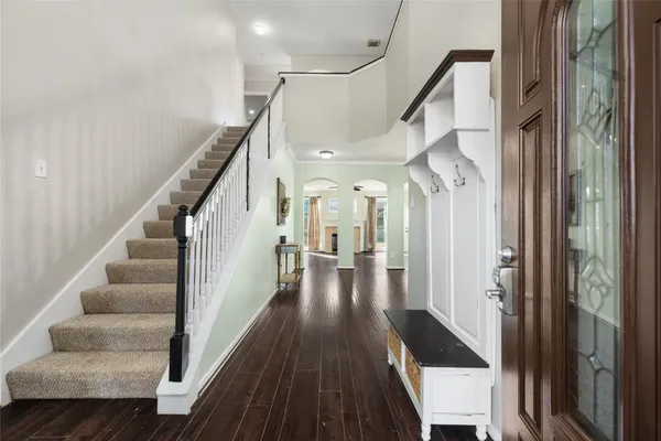 a view of a hallway with wooden floor and staircase