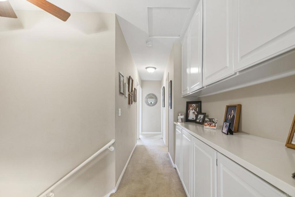 1462 Pegaso Street Encinitas, CA 92024 - Photo 19 of 36 a hallway with a sink and cabinets