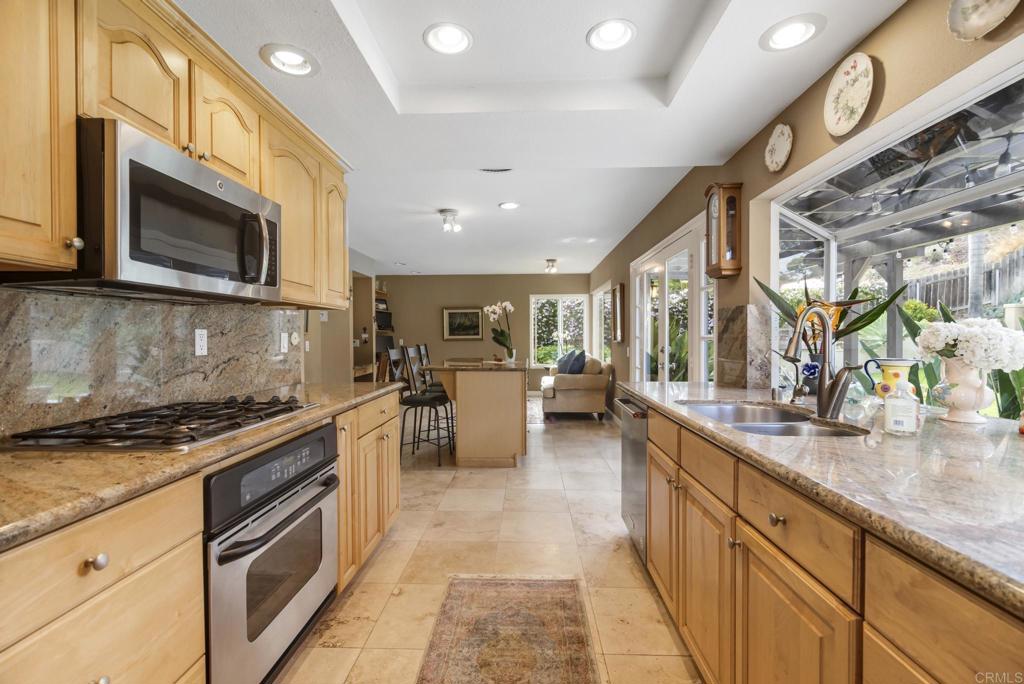 1462 Pegaso Street Encinitas, CA 92024 - Photo 33 of 36 a kitchen with stainless steel appliances granite countertop a stove a sink and a microwave