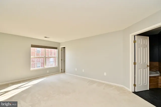 an empty room with closet and windows