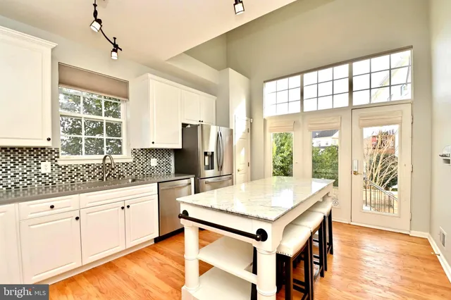 a kitchen with stainless steel appliances granite countertop a sink and a stove