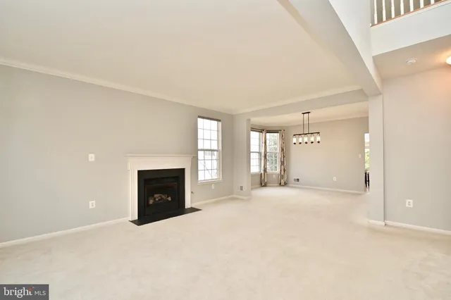 a view of an empty room with a fireplace and a window