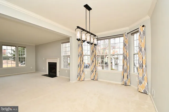 an empty room with windows and fireplace