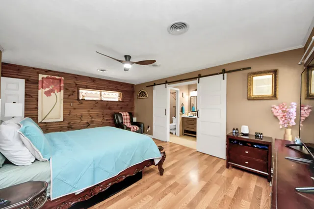 a spacious bedroom with a bed and a flat screen television