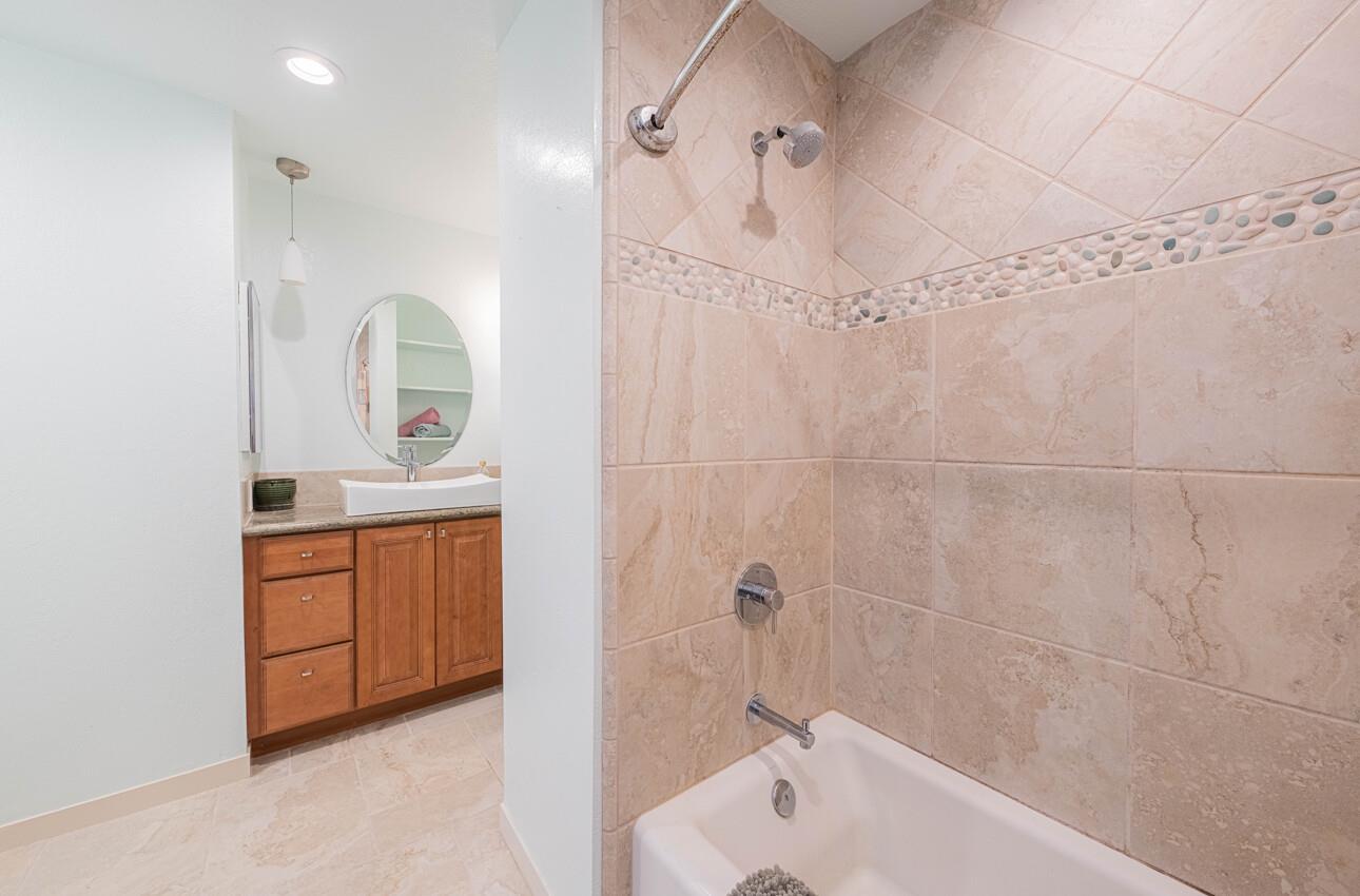 585 Hawthorne Street, Unit 103 Monterey, CA 93940 - Photo 23 of 30 a bathroom with a sink a vanity a mirror a bathtub and shower