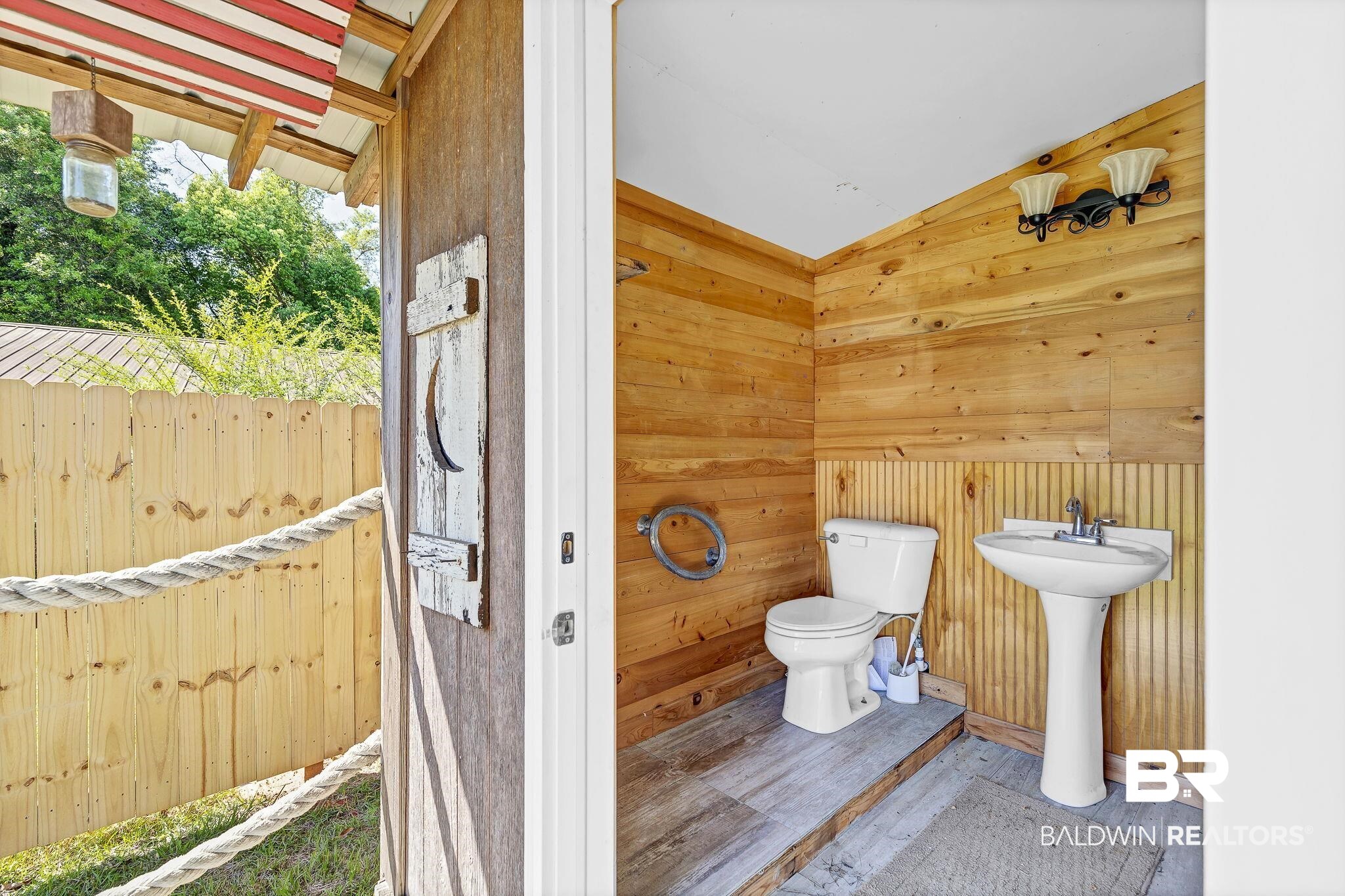 11964 Stroh Road Daphne, AL 36527 - Photo 55 of 58 Half bathroom with toilet, wood finished floors, wood walls, and lofted ceiling