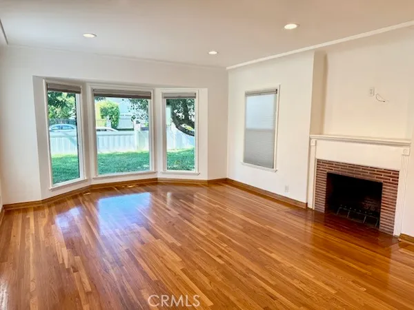 a view of empty room with wooden floor and fireplace
