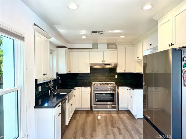 a kitchen with stainless steel appliances a stove a refrigerator and a stove