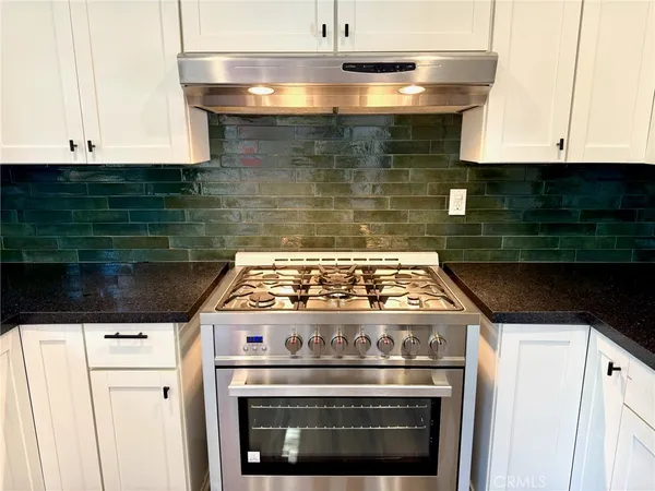 a stove top oven sitting inside of a kitchen