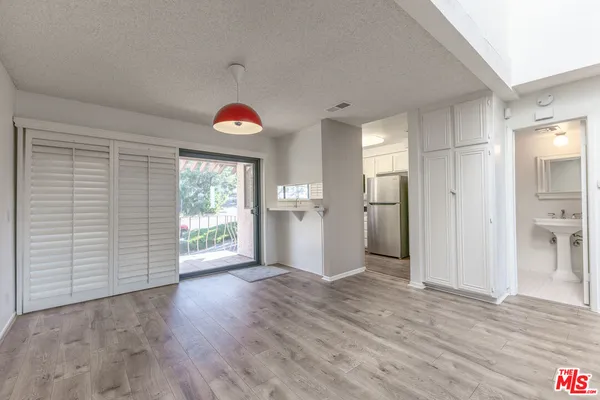 a view of empty room with wooden floor and entryway