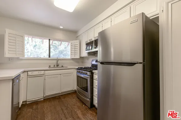 a kitchen with stainless steel appliances granite countertop a refrigerator and a sink