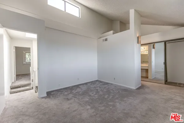 an empty room with closet and a bathroom