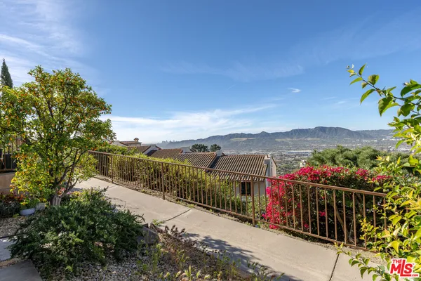 a view of a street with a flower garden in front of it